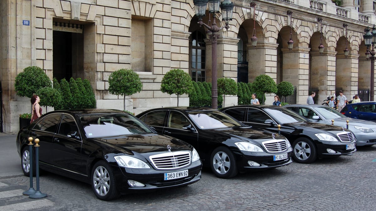 Lineup of black Mercedes-Benz S-Class limousines outside grand palace hotel